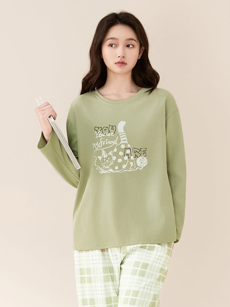 Model wearing a light green long-sleeve graphic top with plaid lounge pants