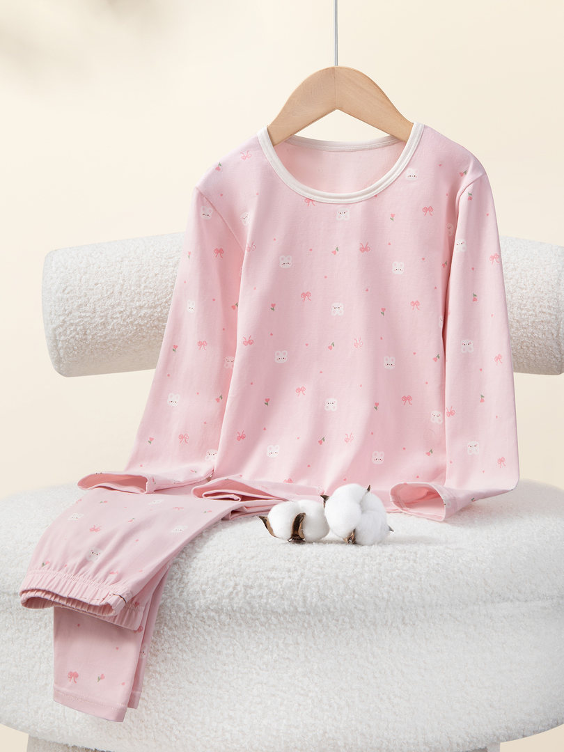 Pink long-sleeve pajama set with small allover print displayed on a hanger and folded pants