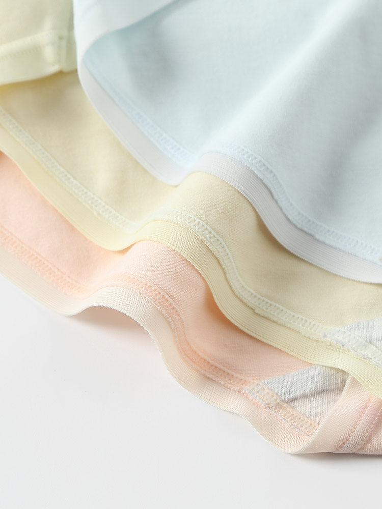 Pastel seamless fabric clothing items stacked in a close-up product shot