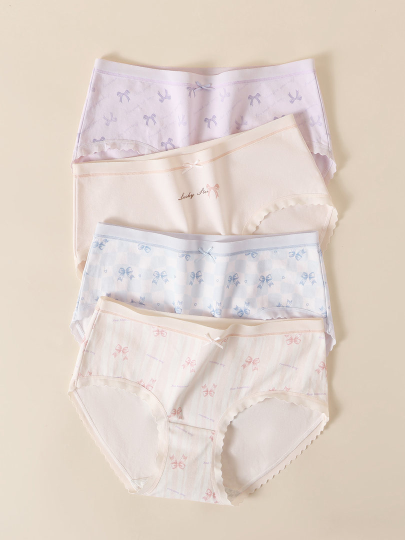 Four pairs of pastel patterned women's underwear laid flat on a beige background