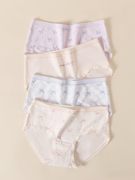 Four pairs of pastel patterned women's underwear laid flat on a beige background
