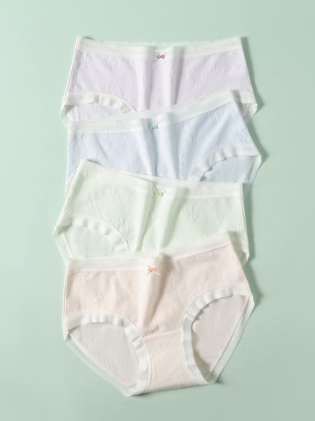 Pastel women’s underwear briefs laid flat on a mint background