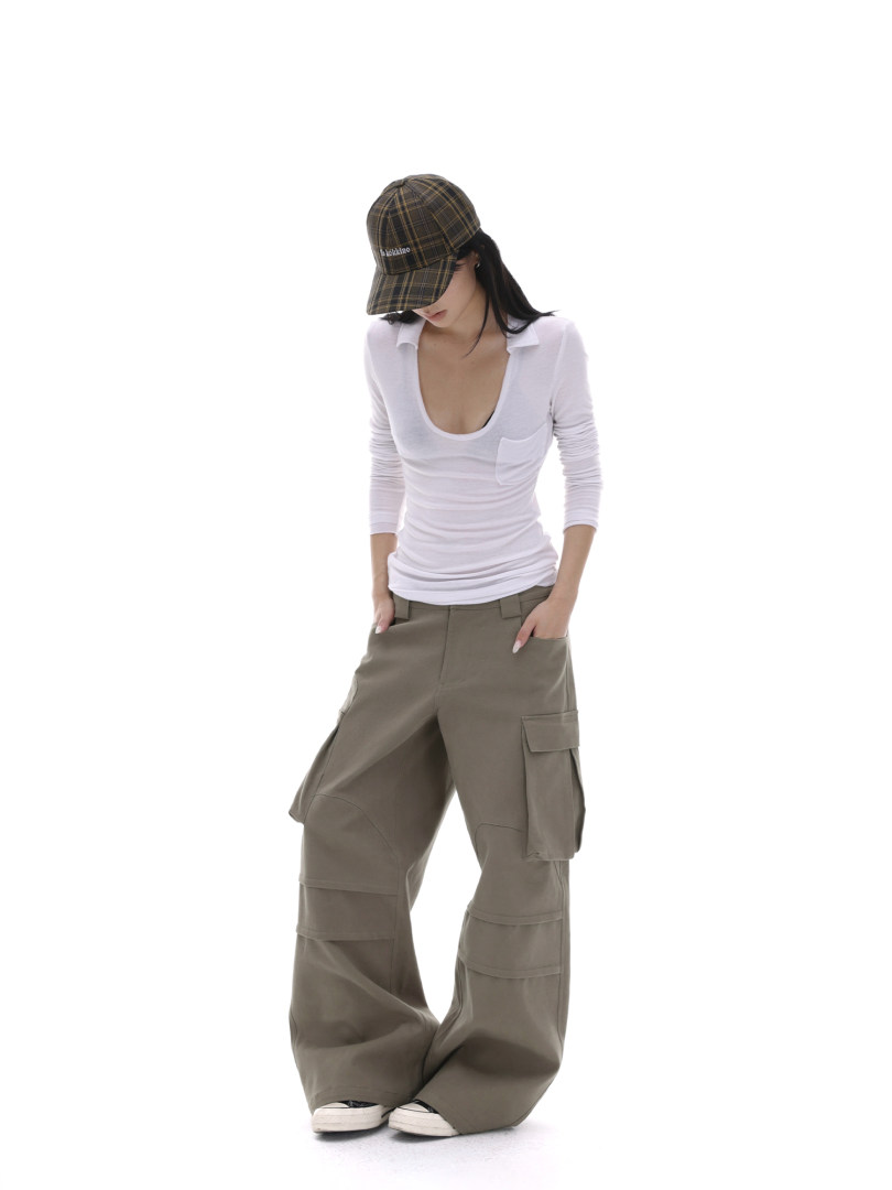 Model wearing a white fitted top, oversized cargo pants, and a plaid cap on a white background