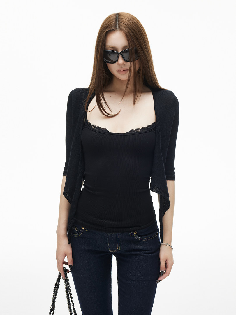 Model wearing a black fitted camisole with a cropped cardigan, jeans, and sunglasses