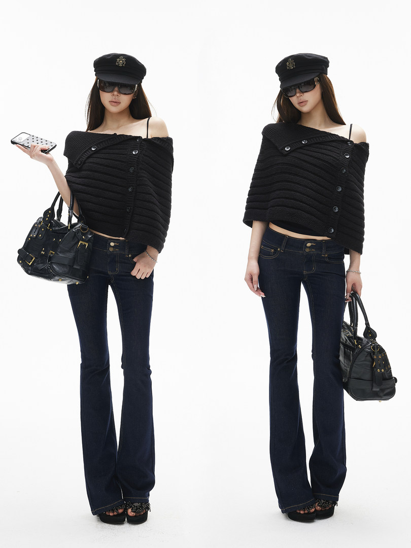 Model wearing a black off-shoulder knit top with dark flared jeans and accessories