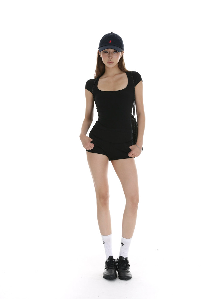 Black fitted short-sleeve mini romper worn by a model with a cap and sneakers
