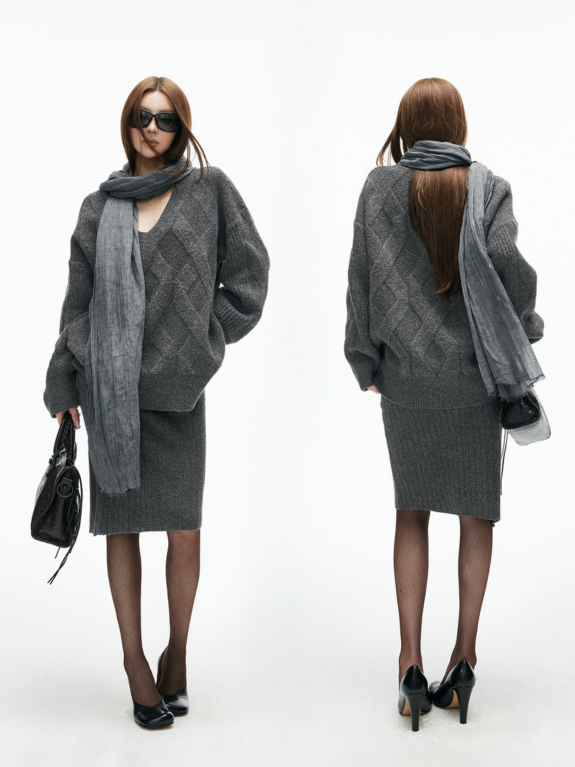 Gray knit sweater and skirt outfit worn by a model with a long scarf and black accessories