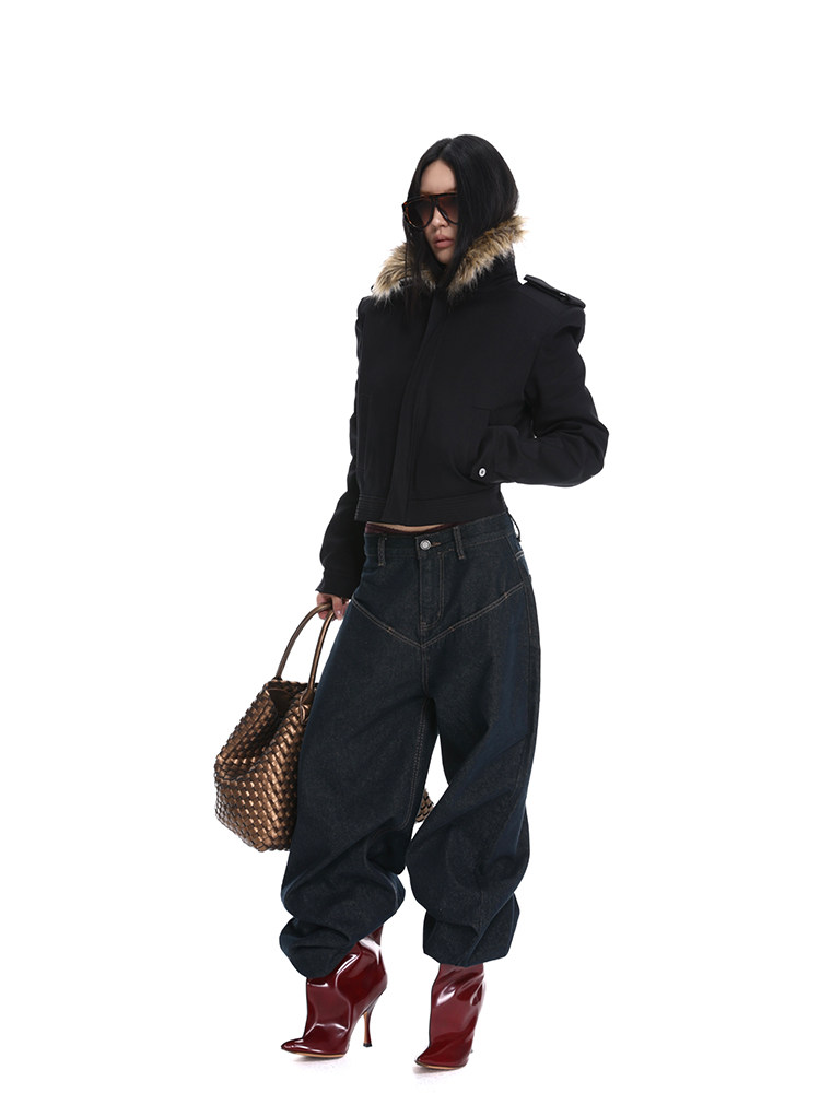 Model wearing a black fur-trim jacket with dark jeans, red heeled boots, and a woven handbag