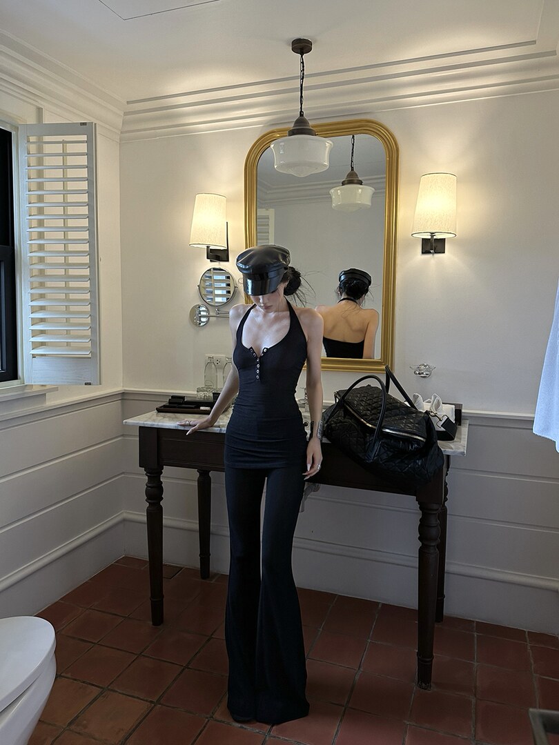 Black fitted halter jumpsuit with flared legs worn by a model