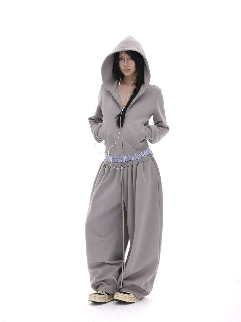 Model wearing a gray hooded zip-up sweatshirt and matching wide-leg pants
