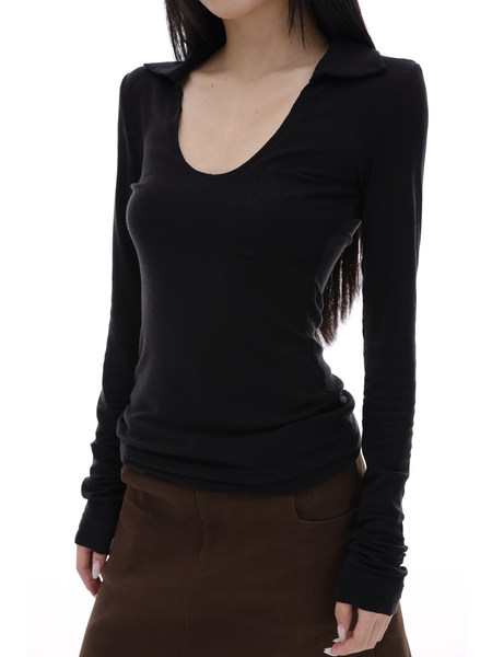 Model wearing a black long-sleeve fitted top with a deep neckline and brown skirt