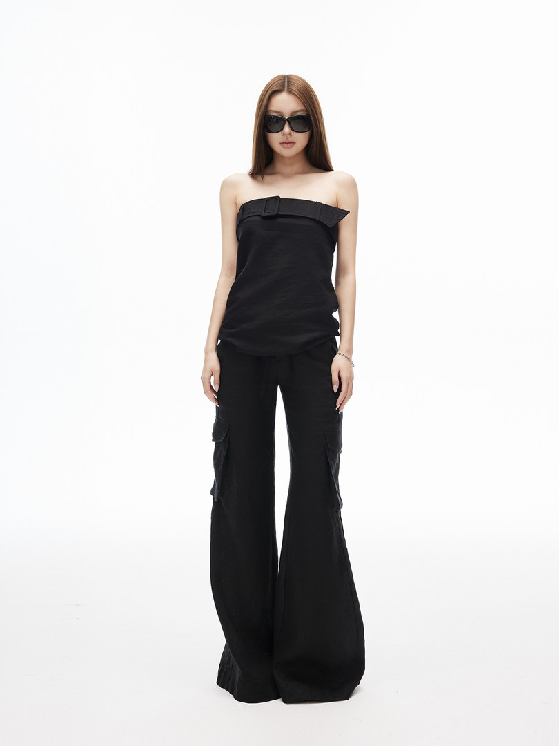 Model wearing a black strapless top and wide-leg cargo pants with sunglasses