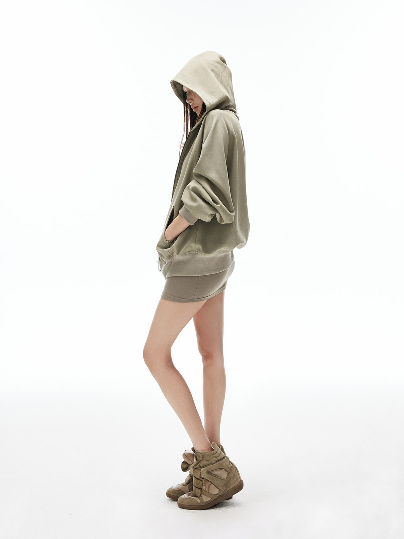 Model wearing an oversized hooded sweatshirt with matching shorts and high-top sneakers