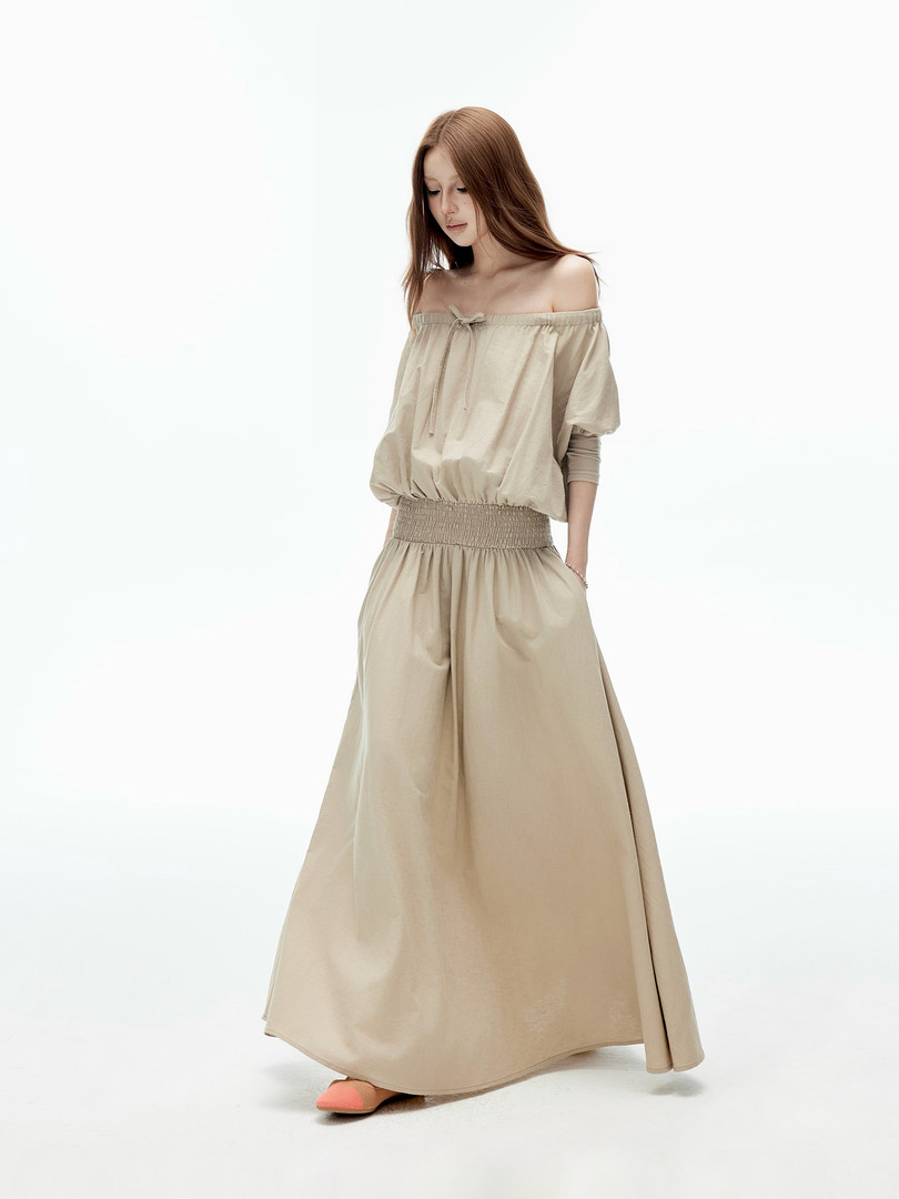 Model wearing a beige off-shoulder long dress