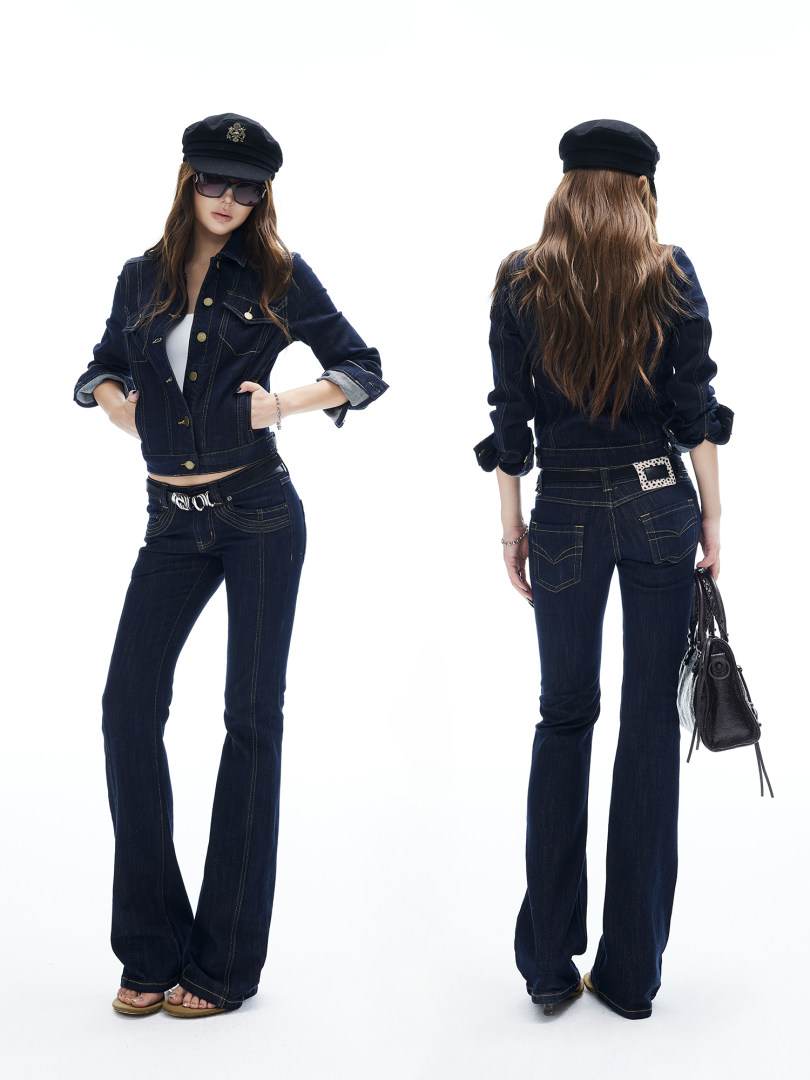 Model wearing a dark denim jacket and flare jeans set with a black cap and sunglasses