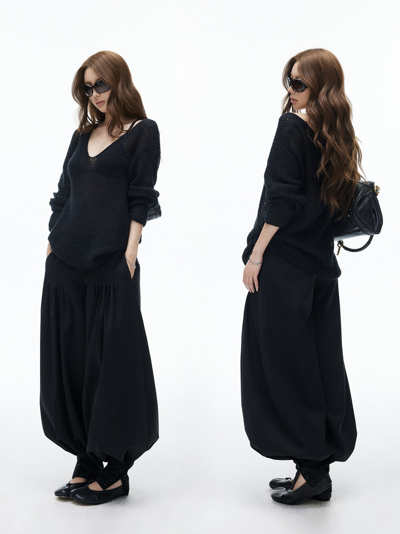 Model wearing a black oversized knit sweater and loose black pants