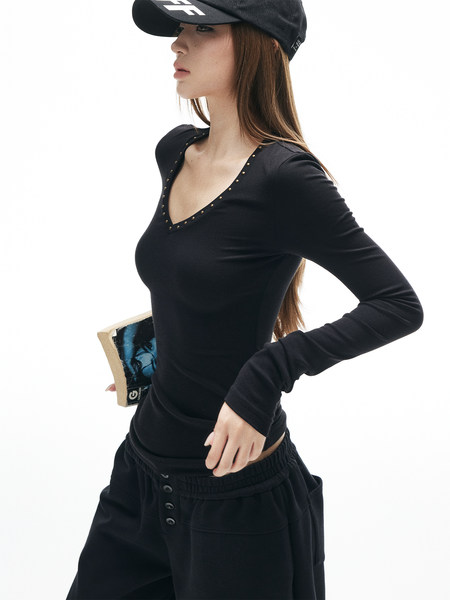 Model wearing a black long-sleeve fitted top and black pants with a black cap