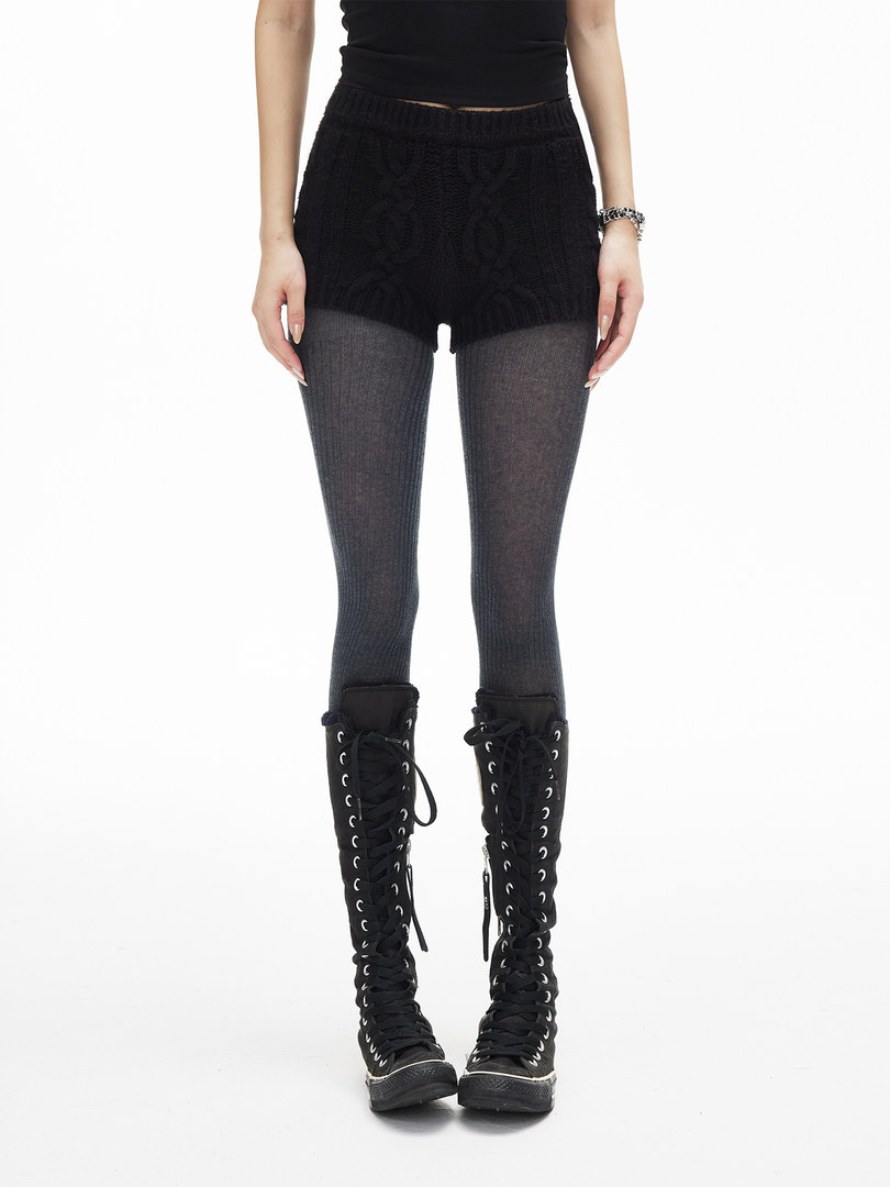 Model wearing black lace-up knee-high boots with tights and shorts