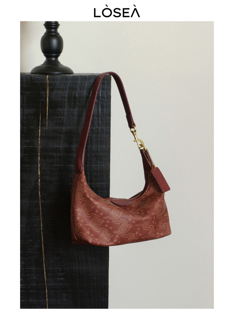 Red patterned shoulder handbag displayed on a neutral background