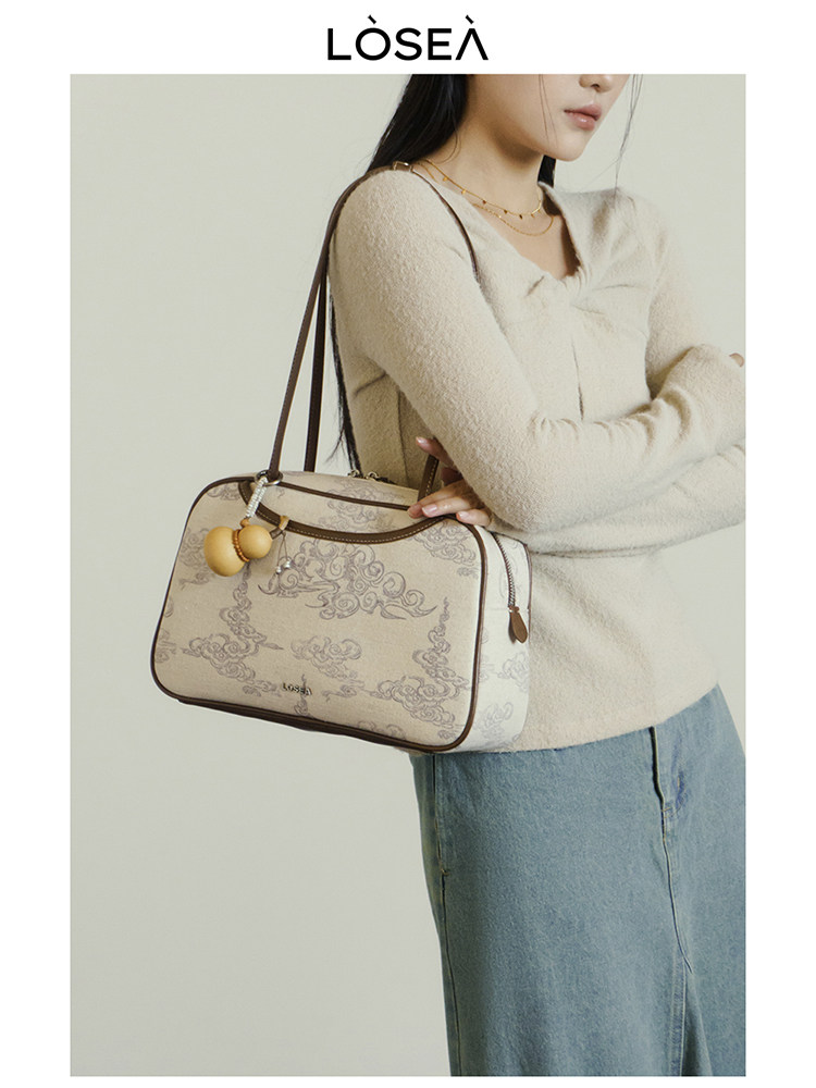Model wearing a patterned shoulder handbag