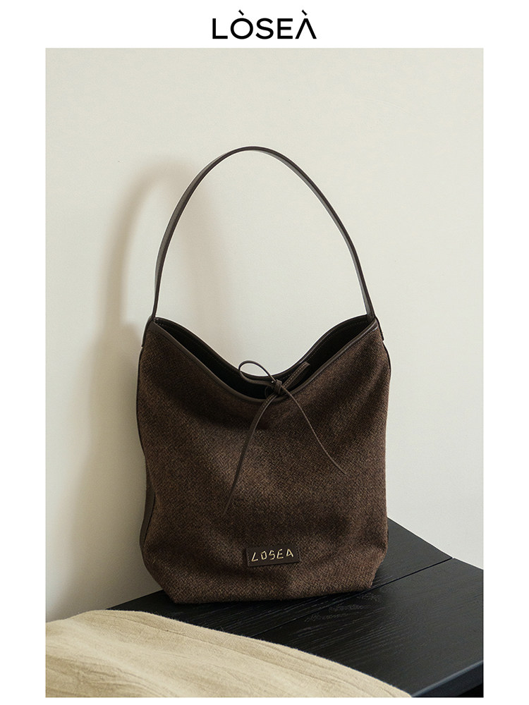 Brown shoulder handbag displayed on a white background