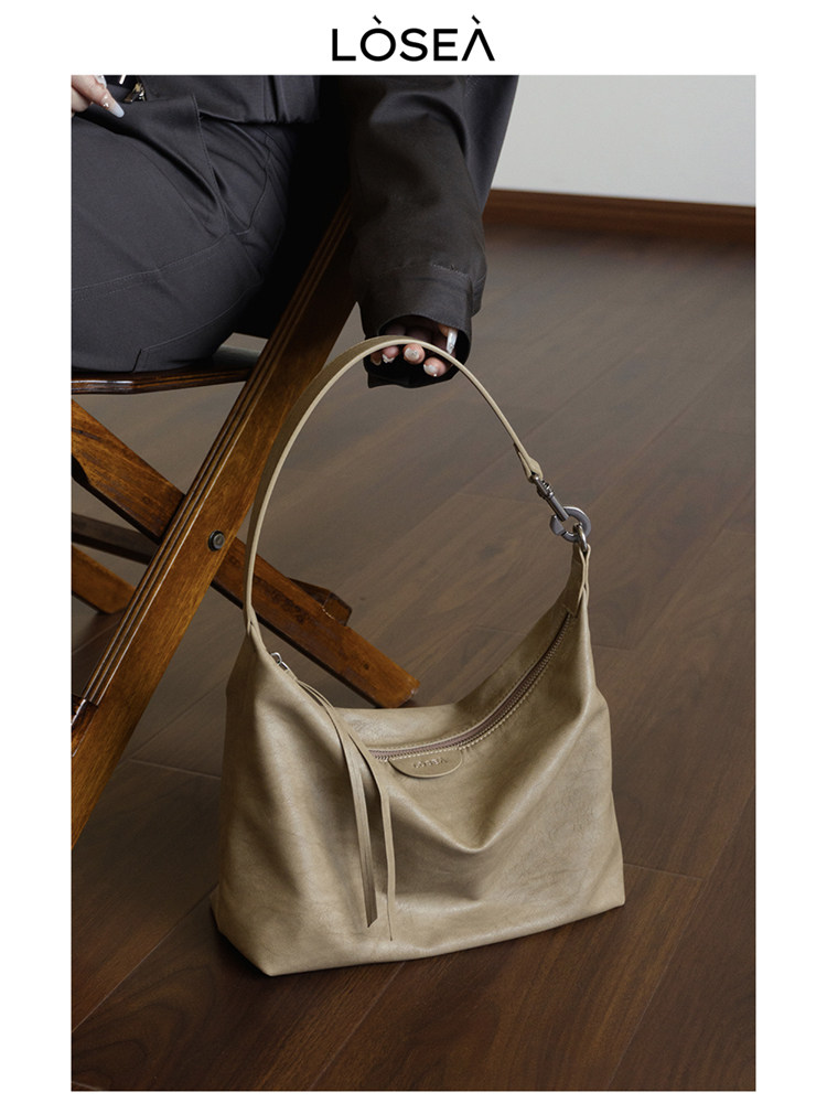 Beige shoulder handbag being held indoors