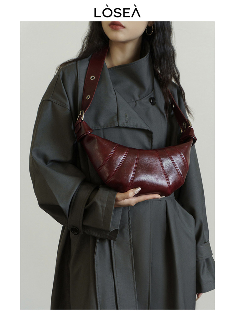 Burgundy leather crescent shoulder bag worn by a model