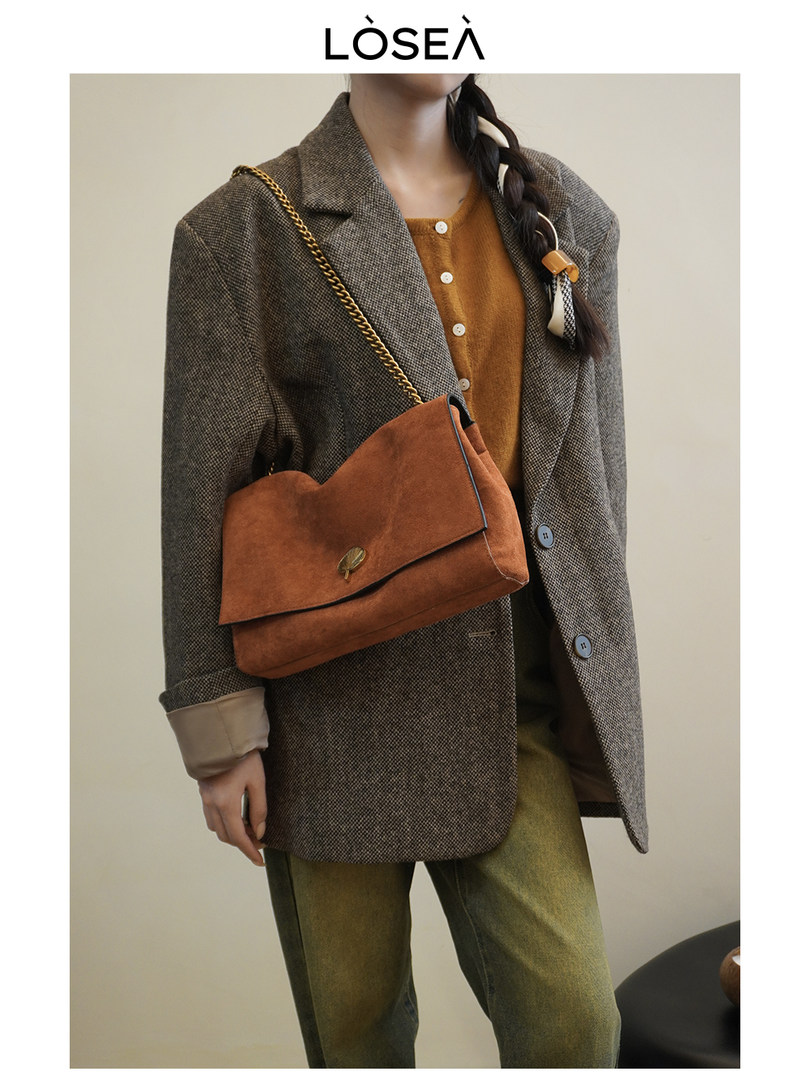 Model wearing a brown blazer outfit with a rust crossbody handbag