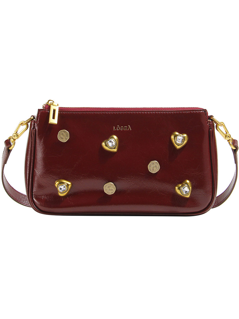 Maroon leather shoulder bag with gold heart embellishments on a white background