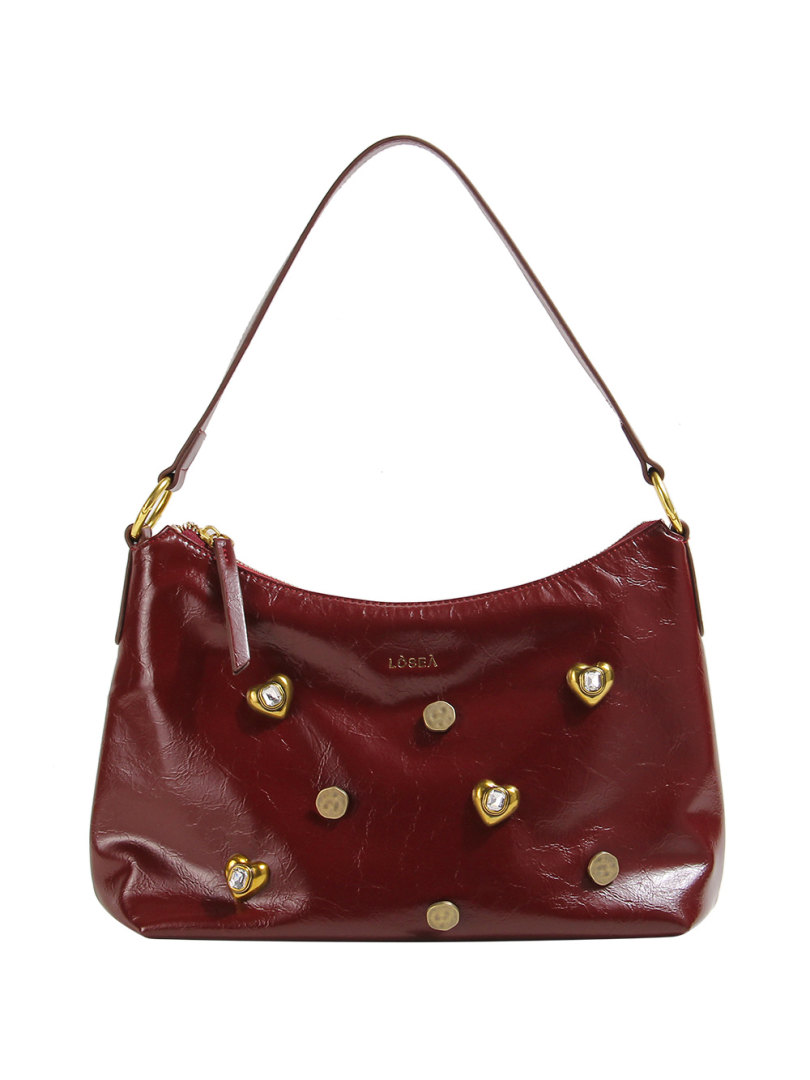 Burgundy leather shoulder handbag with gold-tone heart accents on a white background