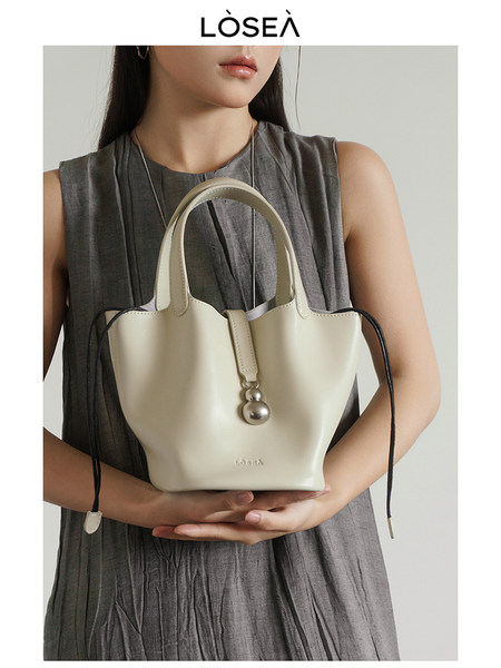 Cream leather tote handbag held by a model