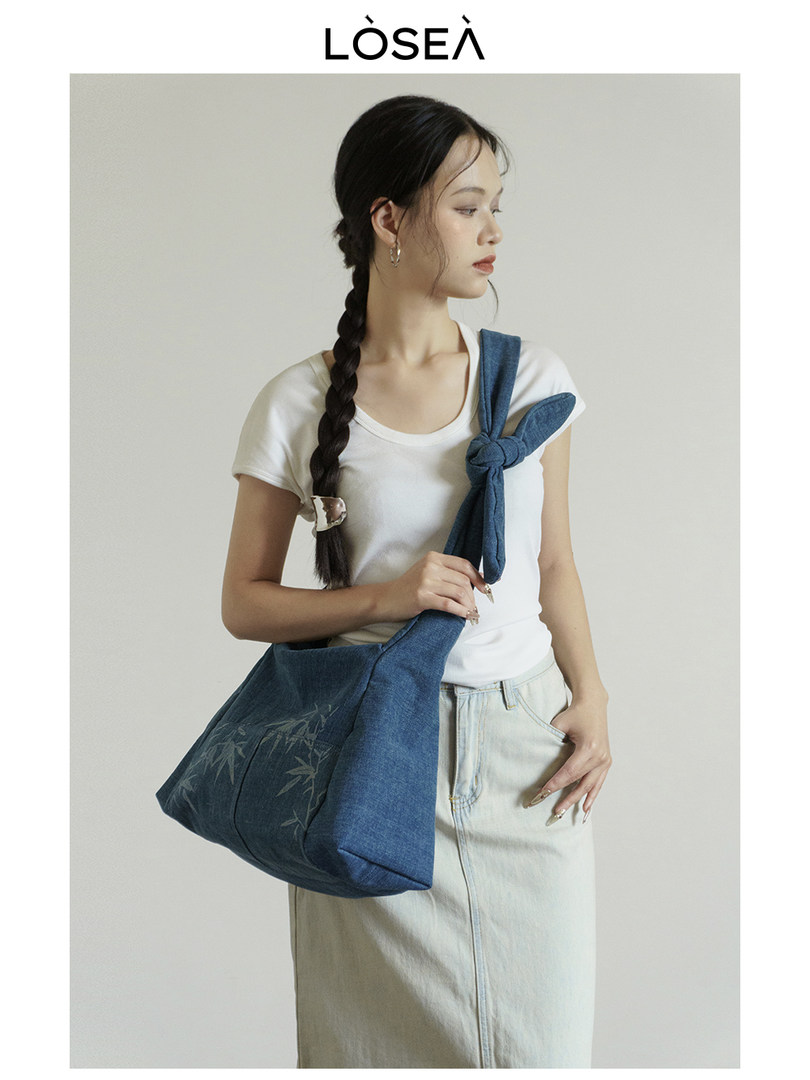 Blue denim shoulder bag worn by a model with casual outfit