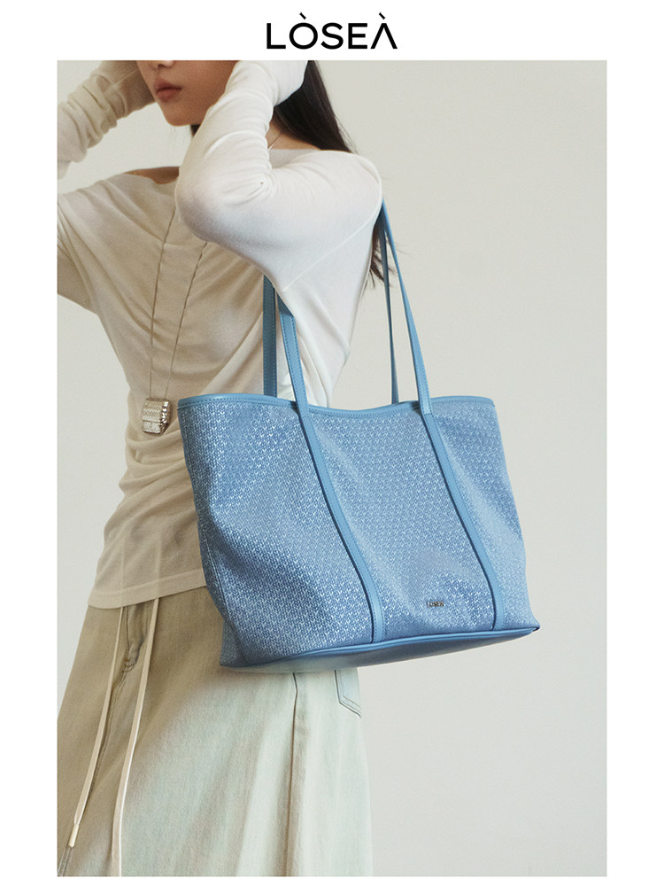 Blue tote bag worn by a model