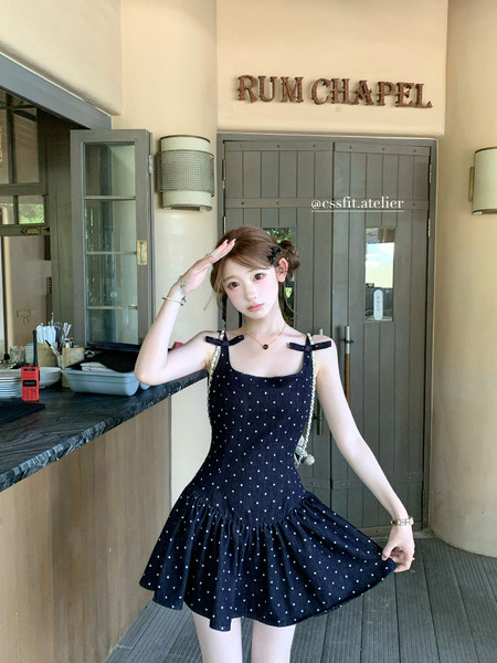 Black polka dot sleeveless mini dress worn by a model