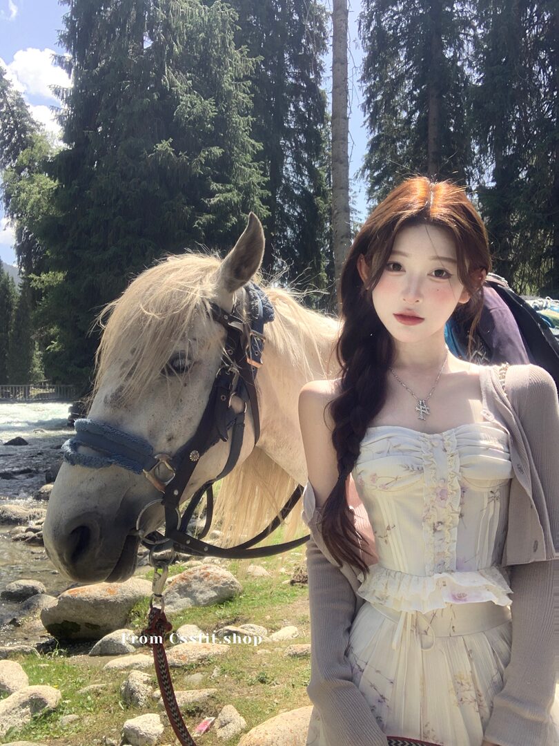 Woman wearing a cream floral dress outdoors beside a horse