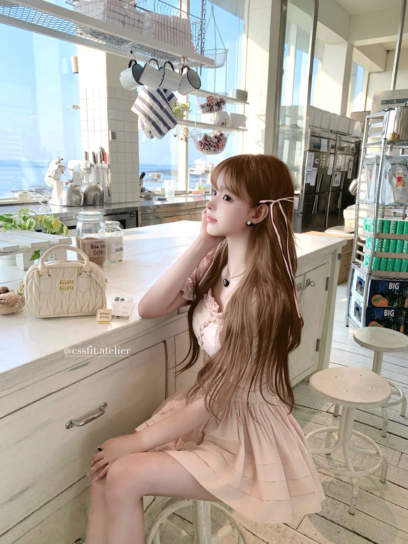Woman wearing a light pink dress in a bright cafe