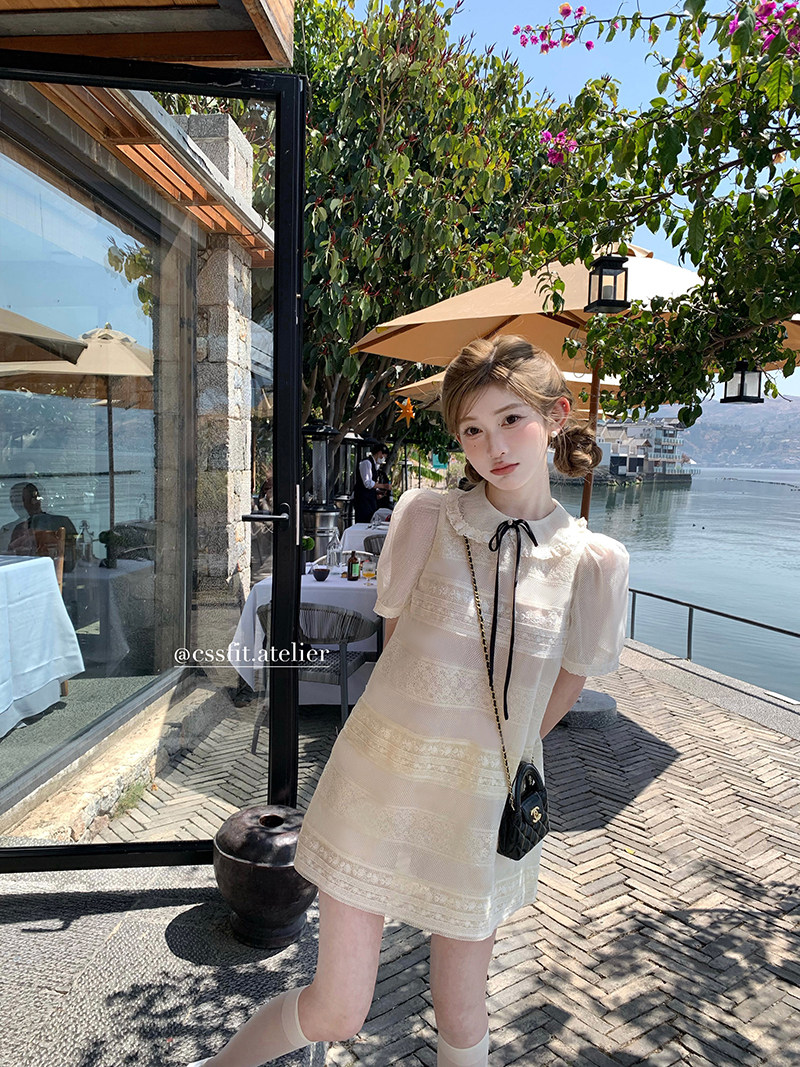 Cream lace short-sleeve dress worn outdoors by the water