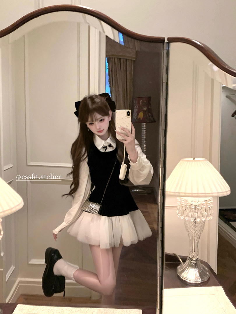 Mirror selfie of a woman wearing a black-and-white preppy dress outfit
