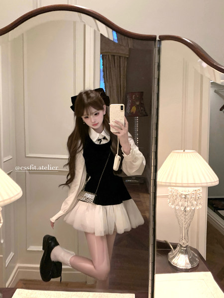 Mirror selfie of a woman wearing a black-and-white preppy dress outfit