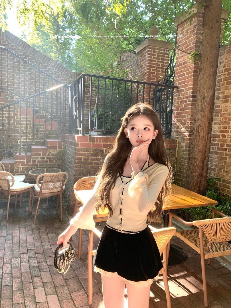 Woman modeling a cream top and black mini skirt outdoors