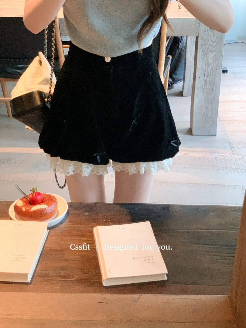 Woman wearing a gray sleeveless top with a black skirt and lace trim in a mirror selfie