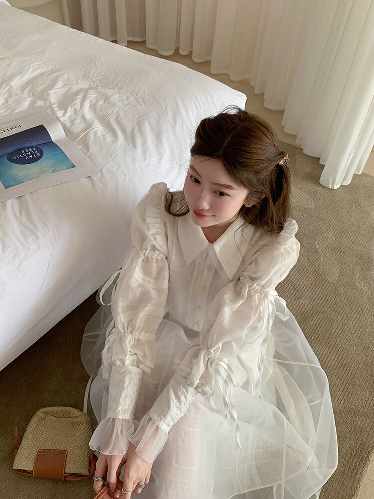 White sheer long-sleeve dress worn by a model indoors