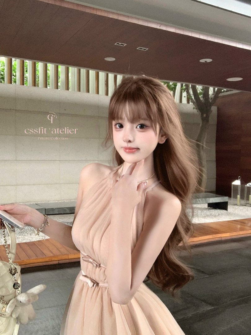 Model wearing a light peach sleeveless dress