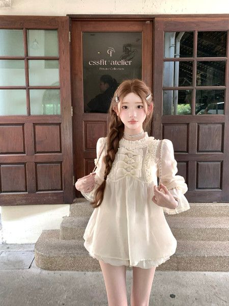 Cream ruffled long-sleeve dress worn by a model