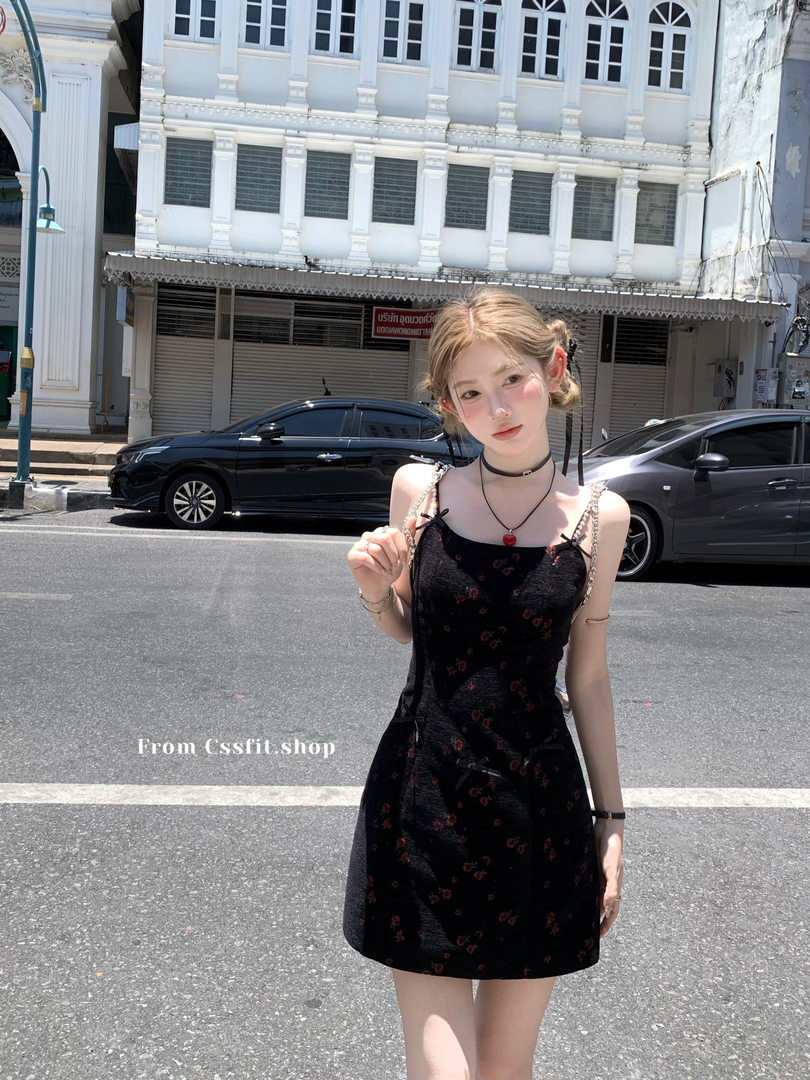Black floral spaghetti-strap mini dress worn by a model outdoors
