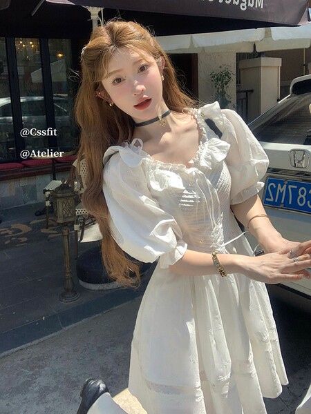 White puff-sleeve dress worn by a female model outdoors