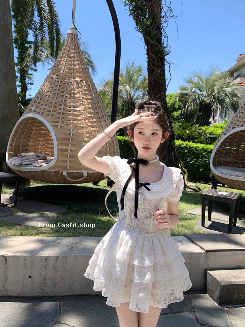 White lace ruffled mini dress worn by a model outdoors