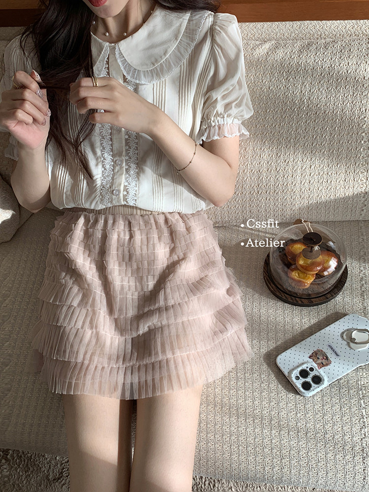 Woman wearing a white ruffled blouse and pink tiered skirt