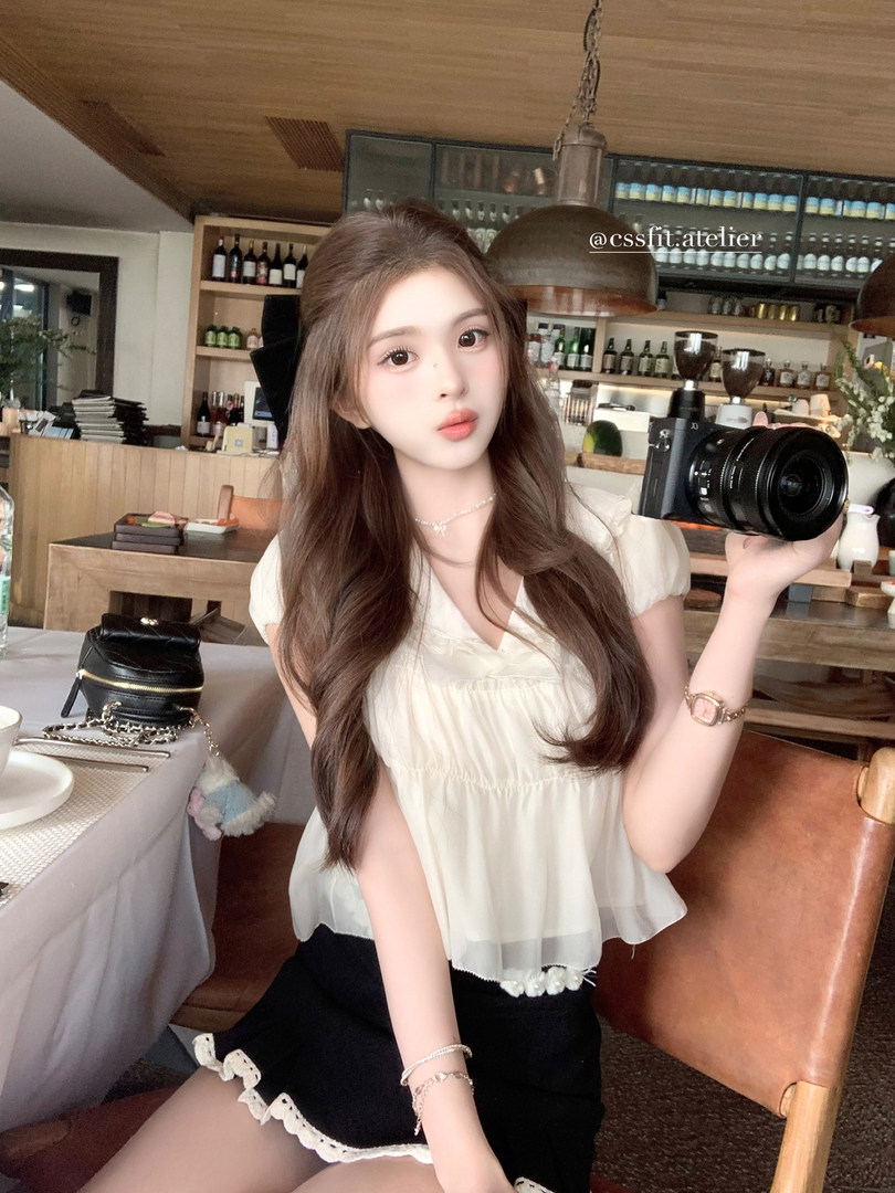 Woman wearing a white blouse and black mini skirt in a cafe