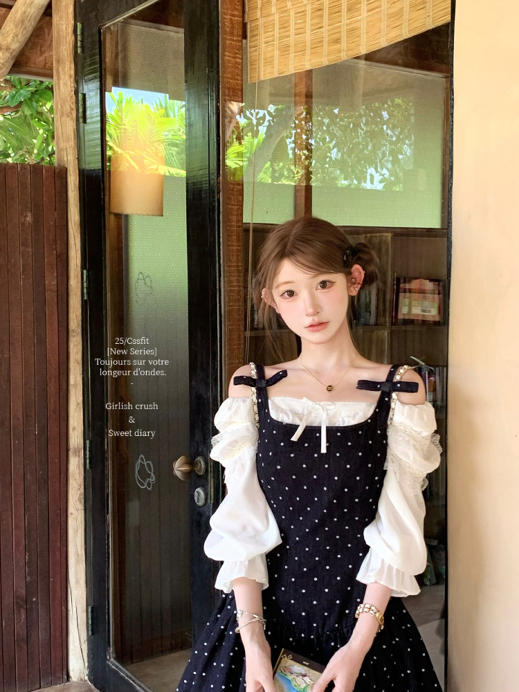 Model wearing a black polka dot off-shoulder dress over a white blouse